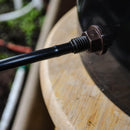 Close-up of a black metal rod with a nut attached to a wooden surface.