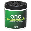 Ona Apple Crumble odor neutralizing block in a green and black container on a white background