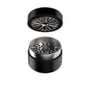 Black metal grinder with top and bottom parts on a white background